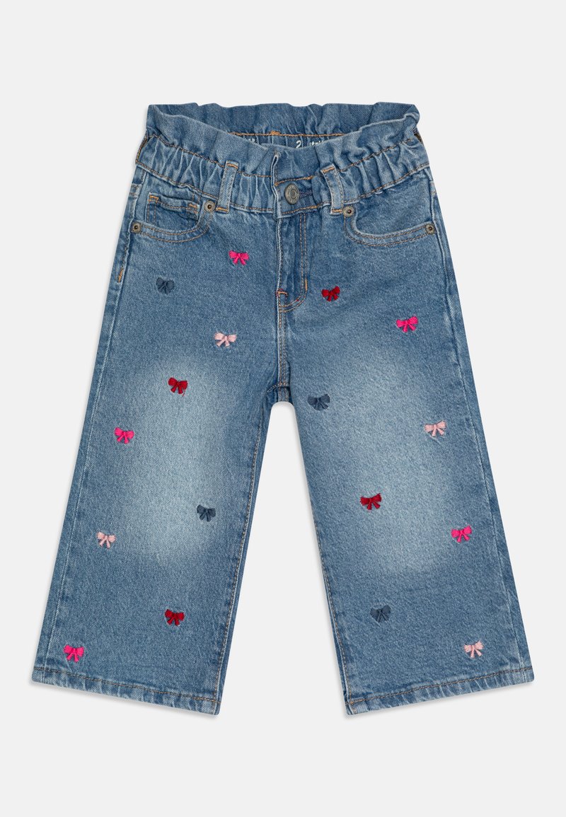 Culottes en denim avec une taille élastique, ornés de nœuds brodés multicolores en rouge, rose et marine, sur un tissu en denim clair délavé.