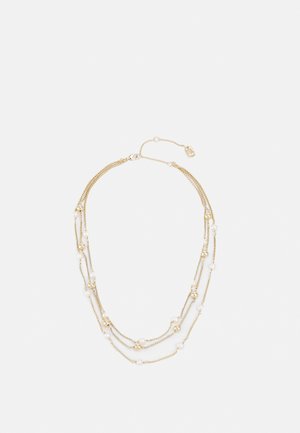 Collier chaîne à couches dorées avec de petites perles blanches et dorées espacées uniformément le long des brins, comprenant un fermoir et un rallonge de chaîne ajustable.