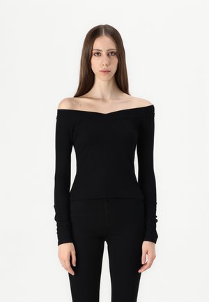 Black off-the-shoulder top with long sleeves, fitted design, and a subtle v-neck. Made from soft, stretchy fabric. Paired with black pants.