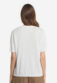 Hvid bomulds t-shirt med korte ærmer, rund halsudskæring og en afslappet pasform. Glat tekstur, enkelt design uden synlige mønstre eller accenter.