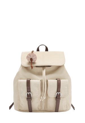 Beżowy plecak na płótnie z klapą do złożenia, brązowymi skórzanymi paskami, dwoma przednimi kieszeniami oraz dekoracyjnym akcentem w kształcie kwiatu.