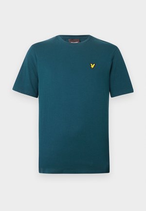 T-shirt en coton couleur sarcelle avec un col rond et des manches courtes. Présente un petit logo d'oiseau jaune sur la partie gauche de la poitrine. Texture lisse.