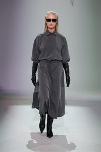 Rochie cămașă gri, cu mâneci lungi și o croială structurat, asortată cu mănuși din piele negre și cizme negre până la coapsă. Finisaj din material neted.