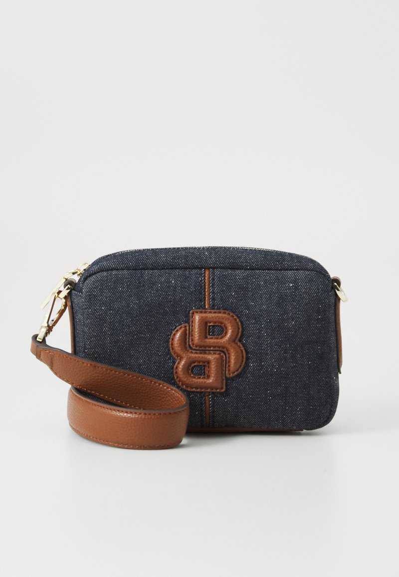 Denimová crossbody taška s hnědou koženou šňůrkou, s hnědým embosovaným logem, zlatým zipem a tmavě modrým texturovaným povrchem.