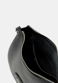 Clutch in pelle nera con superficie texture, chiusura con zip e interno morbido. Presenta diversi slot per carte e una forma arrotondata.