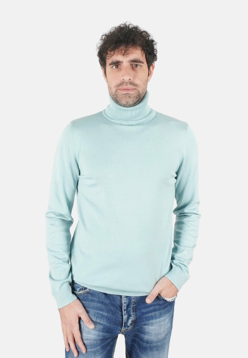 Maglione a collo alto di colore azzurro chiaro realizzato in materiale morbido, caratterizzato da un collo a coste e maniche lunghe, abbinato a jeans di jeans.