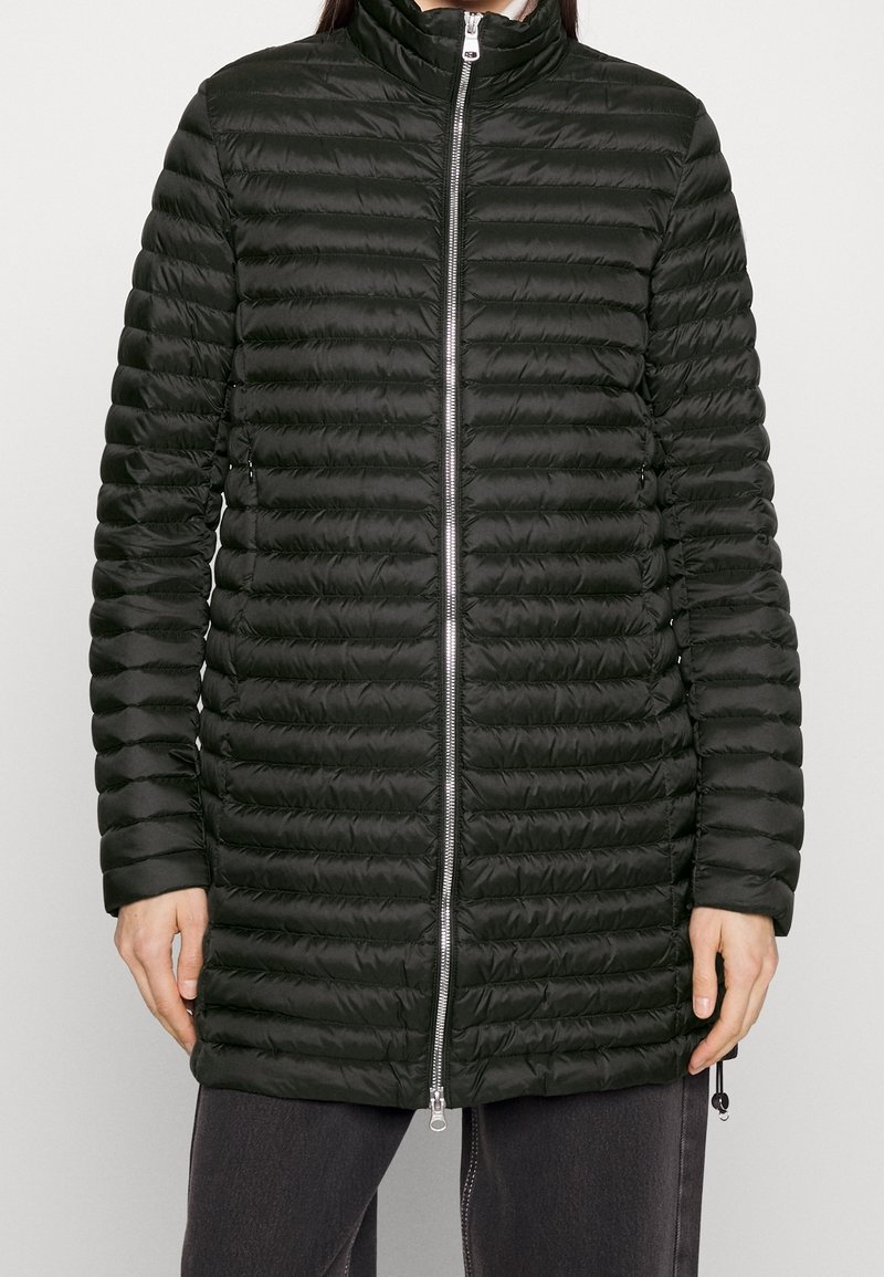 Mörkgrön puffjacka med hög krage, horisontellt quiltad ytstruktur, hel dragkedja och sidofickor, med elastiska manschetter och rundad nederkant.