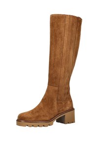 Botas de ante marrón hasta la rodilla con detalles acanalados a lo largo del eje, un tacón grueso y una suela texturizada. Costuras rústicas a lo largo del borde.