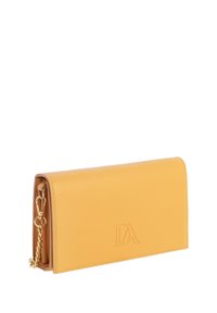 Bolso de mano de piel amarilla con cadena dorada y logotipo en relieve "DA", mostrado sobre un fondo blanco.