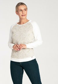 Lekki sweatshirt z teksturowanym wzorem w kształcie plastra miodu w kremowych i pastelowych kolorach, z białymi rękawami raglanowymi i dopasowanym dołem.