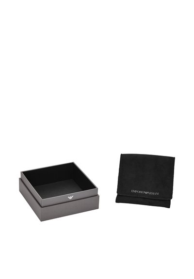 Grå rektangulær kasse med blødt indvendigt, med et sølv logo; ved siden af en sort ruskindspose med brandtekst.