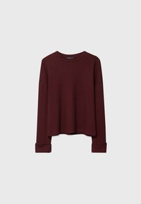 Pull à manches longues en maille côtelée bordeaux foncé avec col rond et poignets repliés, présenté sur un fond clair uni.