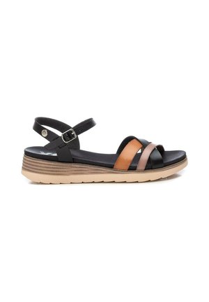 Sandalia de tiras en negro, marrón y beige con hebilla ajustable en el tobillo y suela acolchada con diseño en capas marrón y tostado.