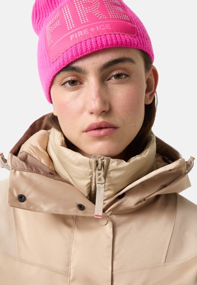 Beige pufferjack met hoge kraag en ritssluiting, gecombineerd met een levendige roze geribbelde gebreide muts met het "FIRE+ICE"-logo.