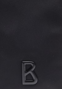 Svart texturerad tyg med en framträdande matt svart "B"-logotyp. Enkel, rektangulär form med en slät yta och minimal detaljering.