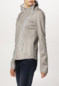 Giacca grigia chiaro con texture, colletto alto, zip asimmetrica e maniche lunghe, realizzata in materiale traspirante.