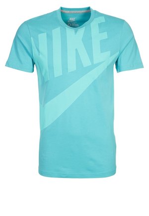 T-shirt Nike bleu clair en coton, arborant un grand logo Nike et un swoosh dans un ton de bleu légèrement plus foncé, avec un col rond et des manches courtes.