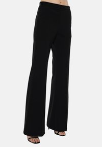 Pantaloni neri con gamba ampia, dalla texture liscia e vita elastica; presentano tasche laterali e un design fluido per un fit rilassato.