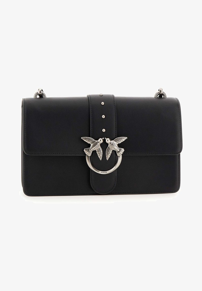 Melna ādas rokas soma ar priekšējo atloku, sudraba putna rotājumu un dekoratīviem kniedēm centrā. Iekļauj apaļu aparatūras aizdari.