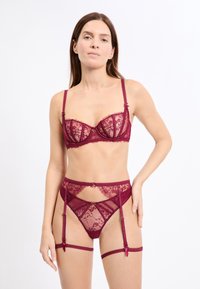 Bordeauxrotes Spitzen-BH- und Strapsgürtel-Set mit transparenten Einsätzen, Bügelunterstützung und dekorativen Akzenten, mit filigranen Blumenmustern.