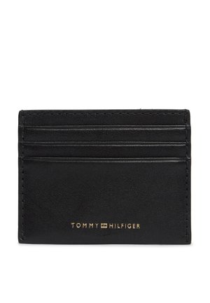 Tarjetero de cuero negro con tres ranuras para tarjetas y logo dorado de Tommy Hilfiger centrado en la parte inferior.