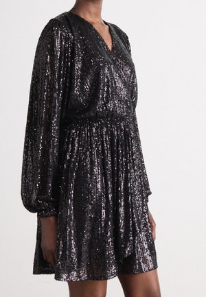 Robe courte noire à manches longues et col en V, couverte de sequins brillants, avec une taille froncée et une jupe ample et fluide.