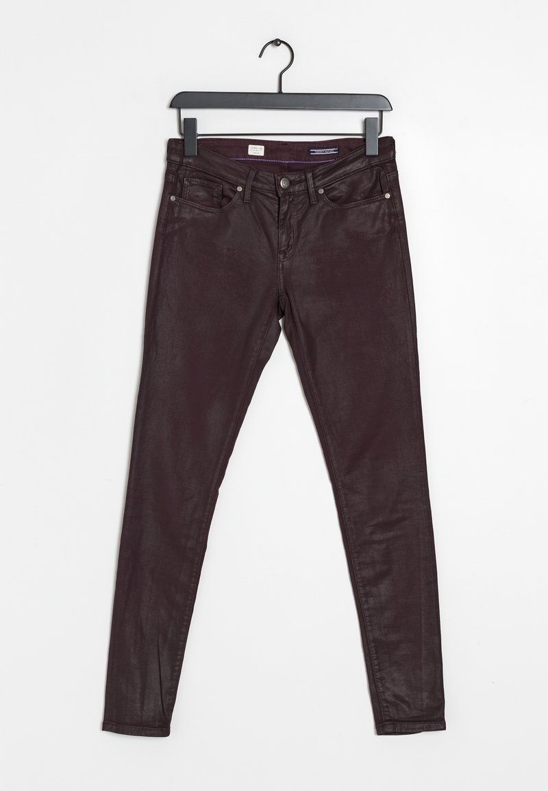 Jeans slim fit marrone scuro appesi a un gancio nero su uno sfondo bianco, che mostrano le tasche anteriori e la chiusura con bottone.