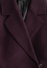 Wollmischungsjacke in tiefem Lila mit strukturiertem Finish, ausgestattet mit einem breiten Reverskragen und einer einzelnen Knopfverschluss. Gefüttert mit schwarzem Satin.