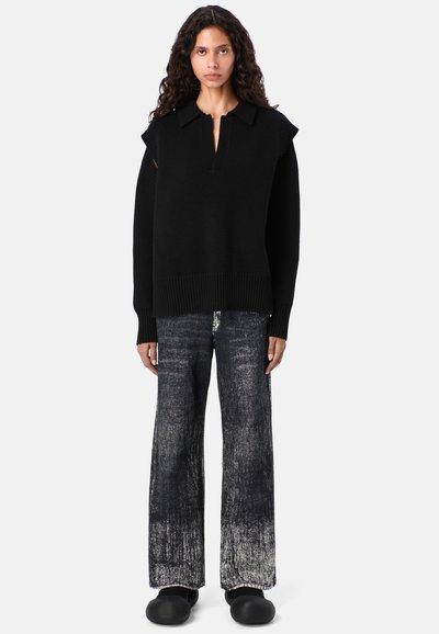 Czarny sweter dzianinowy z kołnierzykiem polo, prążkowanymi mankietami i dołem. W połączeniu z jeansami o szerokich nogawkach w zniszczonym czarnym i szarym wzorze. Czarne saboty.