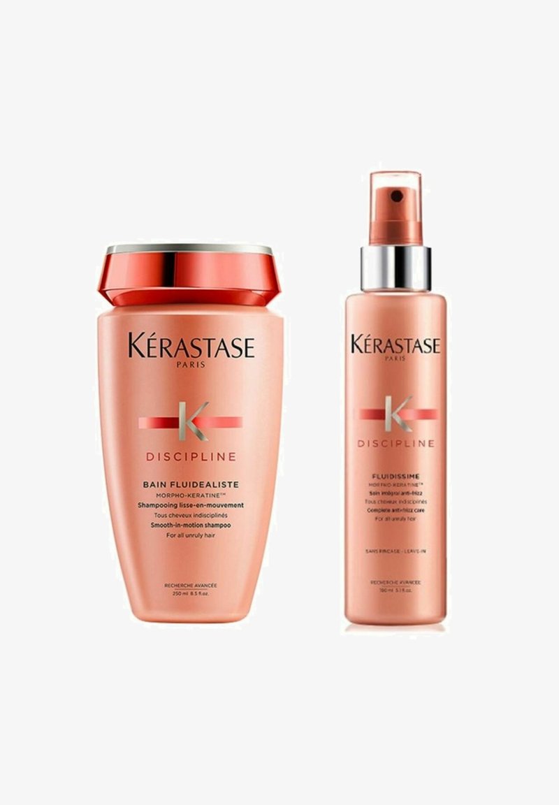 Kérastase Haarpflegeprodukte: eine pinke Shampooflasche mit rotem Deckel und eine passende pinke Sprühflasche mit silbernen Akzenten, beschriftet mit "Discipline."