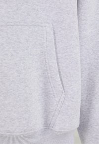 Gray sweatshirt fabric with a soft texture, featuring a front pocket and ribbed cuffs. The surface shows a subtle heathered pattern.