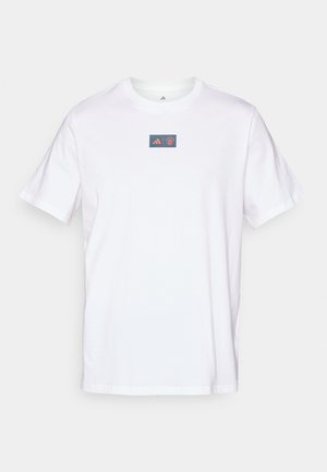 White cotton t-shirt with a crew neck. Features a rectangular logo with a red and blue design on the chest. Short sleeves. Standard fit.
