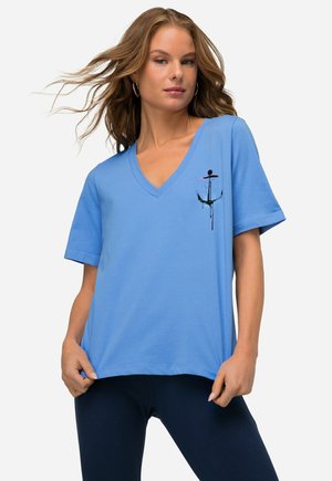 Jasnoniebieska koszulka typu v-neck wykonana z bawełny, w luźnym kroju. Na lewej piersi znajduje się grafika kotwicy w kolorze czarnym i różowym. Krótkie rękawy.