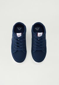 Baskets en toile bleu marine avec semelles en caoutchouc blanches. Les caractéristiques incluent un design à lacets, un renfort à l'avant et un logo sur la languette. Texture lisse.