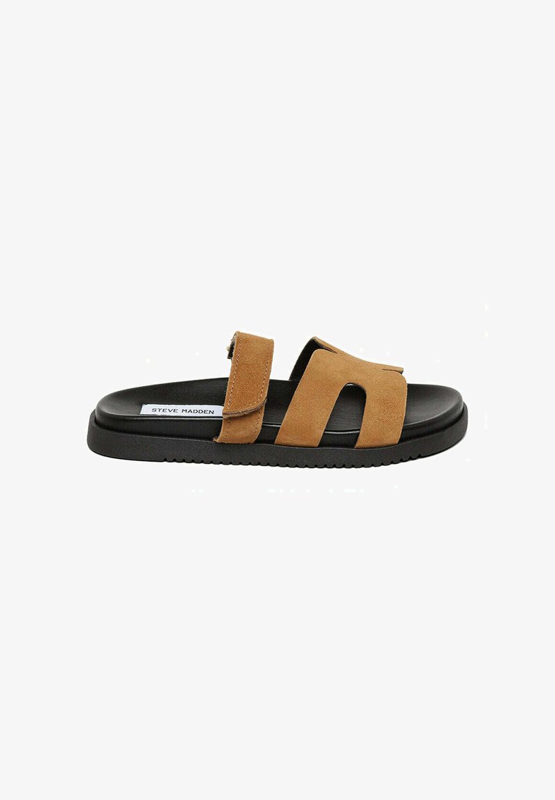 Sandale à glisser en daim brun avec deux sangles réglables, semelle en caoutchouc noire et design plat. Présente un logo de marque visible sur la semelle intérieure.
