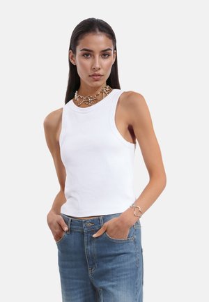 Witte geribbelde tanktop met een aansluitend ontwerp, ronde halslijn en brede armsgaten. Draag met blauwe denim jeans en een zilveren ketting met hartthema.