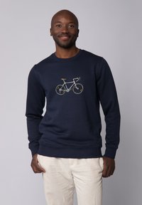Sweat-shirt bleu marine avec un design de bicyclette brodé en blanc et jaune. Texture douce avec un col rond et des manches longues.