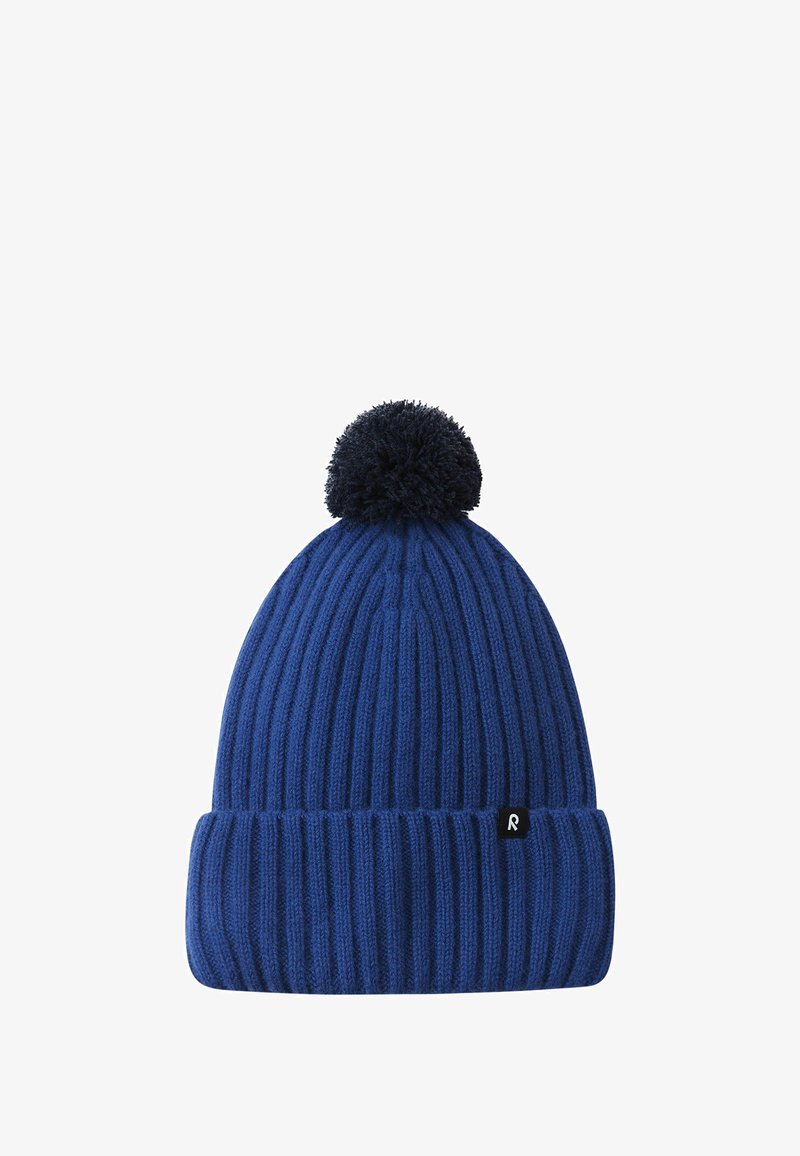 Knitted blue beanie with a ribbed texture, featuring a dark pom-pom on top and a small black logo tag on the folded brim.