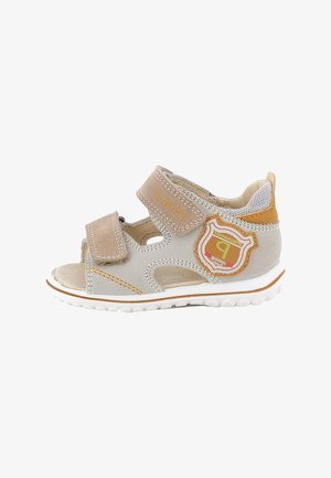 Sandalo beige e marrone chiaro per bambina/o con due cinturini regolabili in velcro e una toppa decorativa sul lato per uso quotidiano.