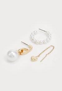 Conjunto de tres pendientes: gancho de metal dorado con una gran perla, aro con perlas y cadena dorada con un pequeño charm en forma de corazón.