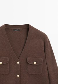 Cardigan a maglia marrone con scollatura a V profonda, due tasche sul petto con dettagli in bottone dorato e una texture morbida. Etichetta: Massimo Dutti.