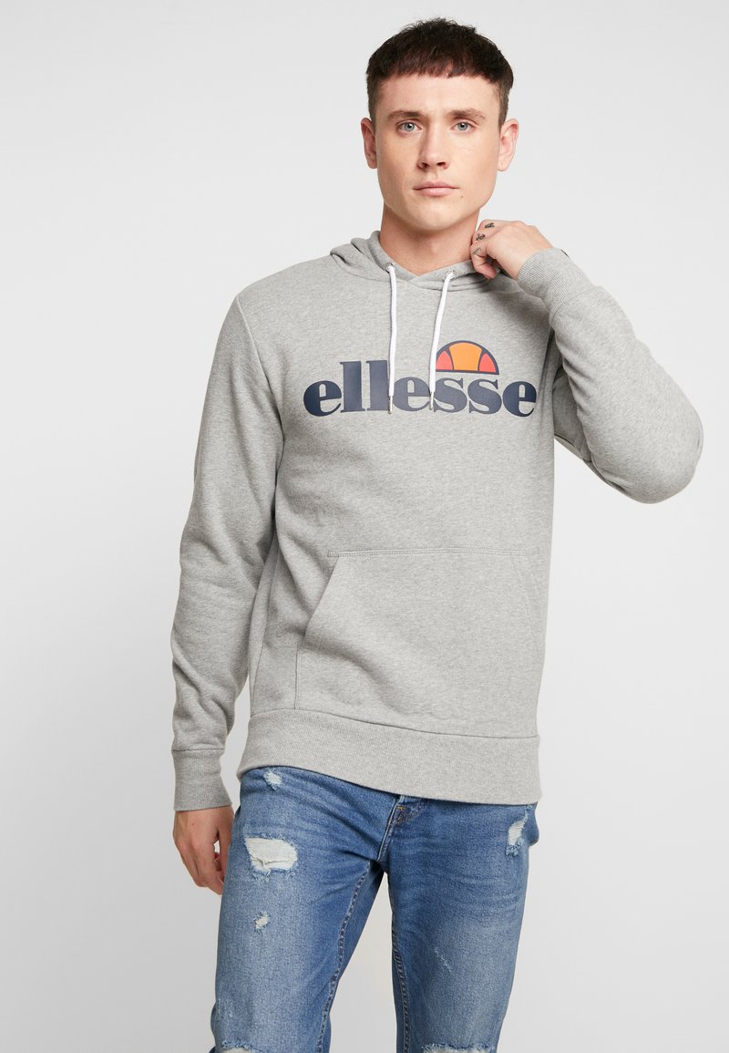 Grijze hoodie van een katoenmix met een voorkantzak en witte koorden. Bevat een groot "ellesse" logo in donkerblauw met een oranje accent.