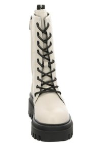 Bota de cuero blanco con cordones, de caña alta, con cordones negros y suela gruesa negra. Presenta un cierre lateral y un acabado texturizado.