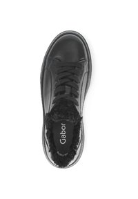 Zwarte leren sneaker met een getextureerde bontvoering en platte veters, voorzien van een ronde neus en subtiele branding op de binnenzool.