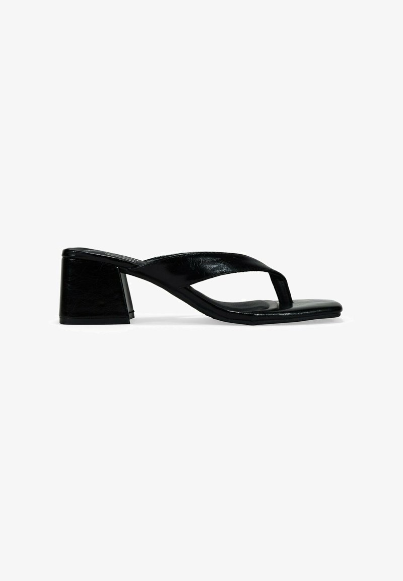 Sandali con tacco a blocco in pelle verniciata nera, dal design minimalista e texture liscia e sleek.