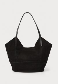 Sac fourre-tout en daim noir avec de longues poignées en cuir, forme arrondie, coutures apparentes et large ouverture. La texture est douce et mate.