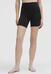 Hochgeschnittene schwarze Shorts aus strukturiertem, dehnbarem Stoff. Mit einem glatten Bund, mittellanger Beinlänge und ohne sichtbare Taschen oder Verzierungen.