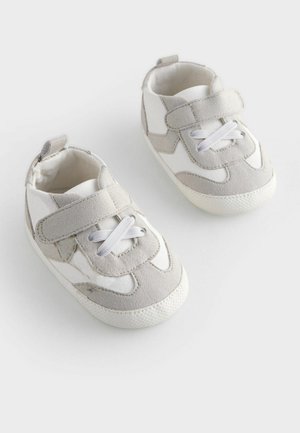 Baskets pour tout-petits grises et blanches avec une sangle velcro, des accents en suede texturé et une semelle en caoutchouc avec une traction à motifs.