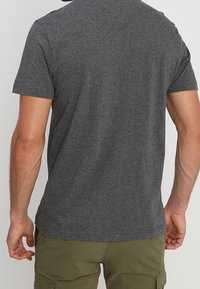 Grå kortærmet T-shirt lavet af blødt stof, med et enkelt design og en rund halsudskæring, med en glat tekstur og ingen synlige tryk.