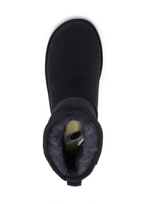 Zwarte suède enkelboot met een ronde neus en een luxe grijze bontvoering. Voorzien van een gestructureerde zwarte elastische boord voor een goede pasvorm.